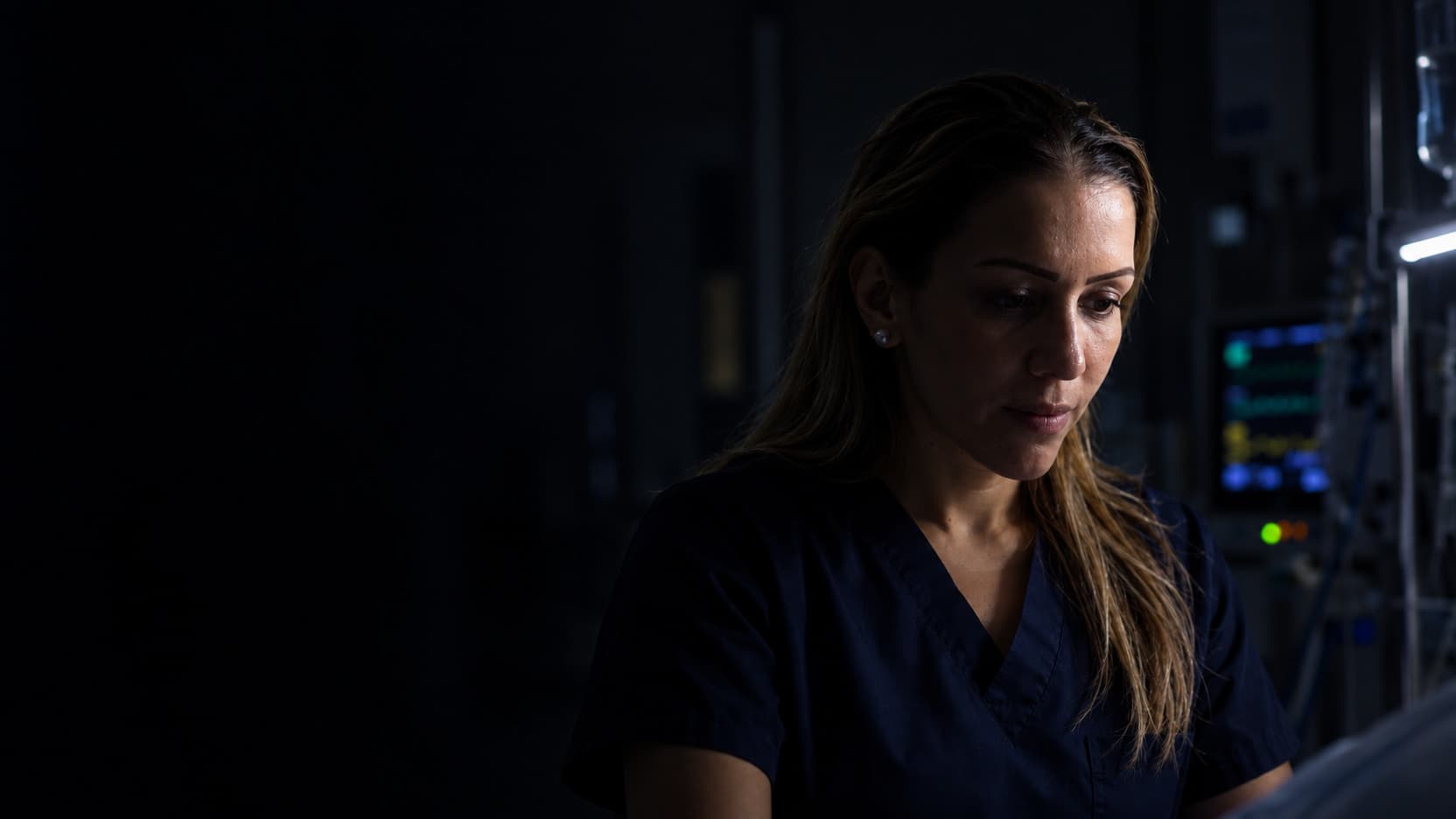 Zeinab Arafat working in a darkened intensive care unit